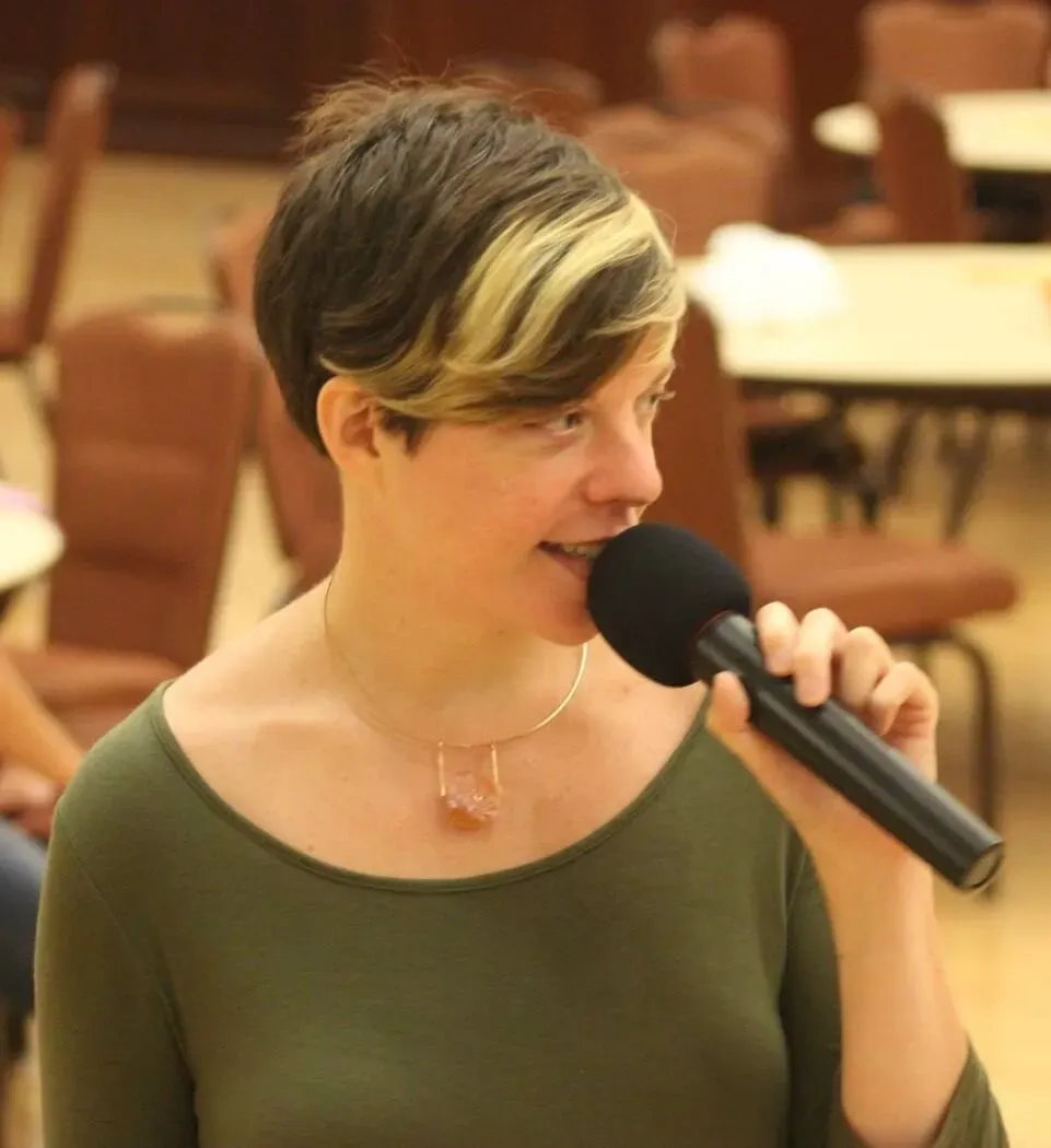 A photo of Louise Siddons speaking into a microphone.