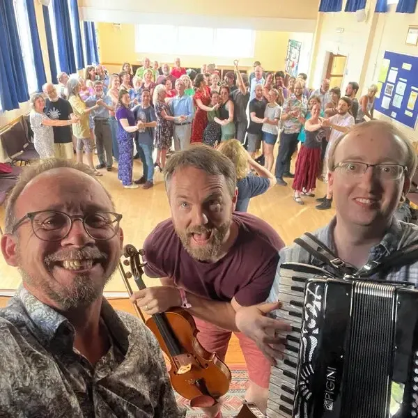 Selfie of Hoik! showing Adam, Edward and Alan in front of a crowd of happy dancers in ballroom hold