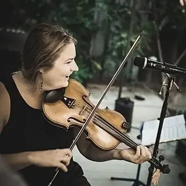 Audrey Jaber laughing and playing a fiddle